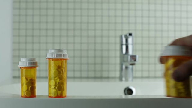 man takes a bottle of pills