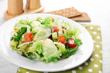 Tasty salmon salad on light wooden background