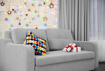 Light grey couch with pillows on Christmas lights background
