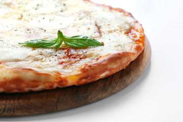 Pizza full of cheese on wooden board isolated on white background, close up