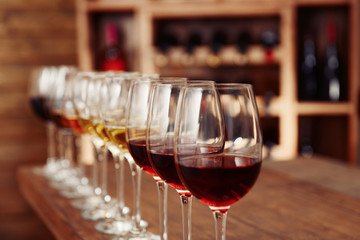 Many glasses of different wine in a row on bar counter