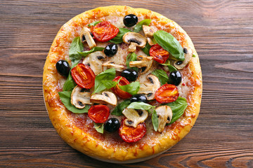 Delicious tasty pizza with ingredients on wooden table