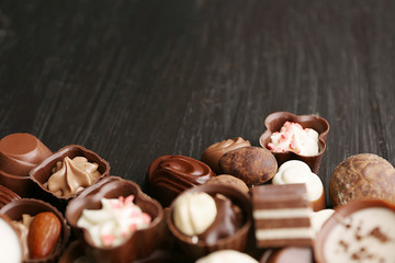 Delicious chocolate candies on wooden background, close up