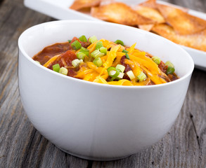 chili con carne bowl over a wooden table