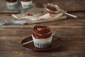 Chocolate cupcake with fork on wooden background