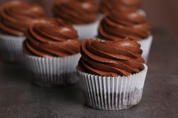 Chocolate cupcakes on grey background, close up