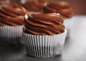 Chocolate cupcakes on grey background, close up