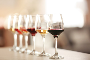 Many glasses of different wine in a row on a table