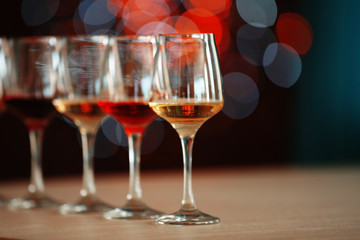 Many glasses of different wine in a row on a table