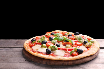 Delicious pizza with cheese and vegetables on black background