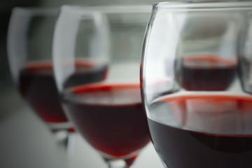 Glasses of red wine on white table closeup