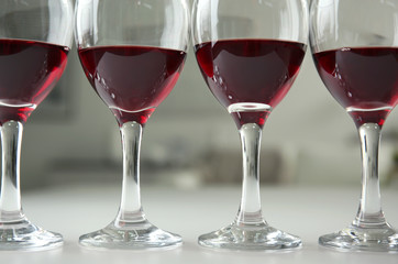 Glasses of red wine on white table closeup