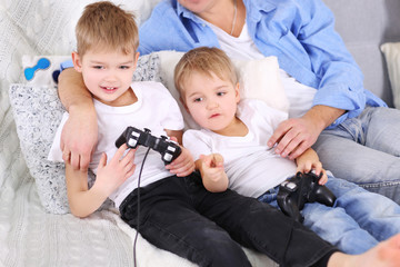 Family concept. Father with sons are playing video games in the room