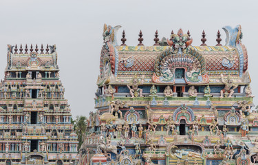 Fototapeta na wymiar Trichy, India - October 15, 2013: two gopurams of the temple in one shot, pastel colored with plenty of statues including the main Ranganathar depiction of Vishnu.