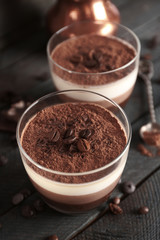 Delicious dessert with chocolate powder and coffee beans in glass
