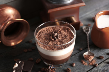 Delicious dessert with chocolate powder and coffee beans in glass