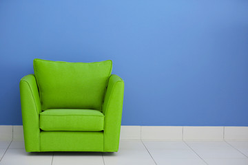 Comfortable armchair against blue wall background