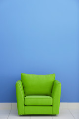 Comfortable armchair against blue wall background