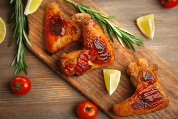 Grilled chicken wings with garden-stuff and tomatoes on cutting board