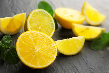 Fototapeta na wymiar Slices of fresh lemon and lime on black textured background
