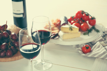 Glasses of red wine with food on table closeup