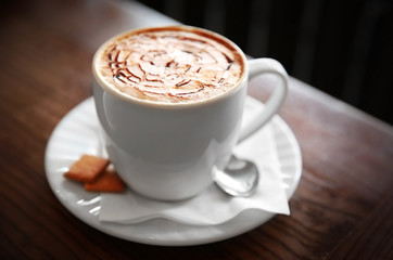 Cup of cappuccino on table in cafe