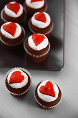 Cupcakes on plate on a light wooden background