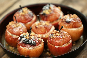 Baked apples with cottage cheese, raisins and walnut in pan, close up