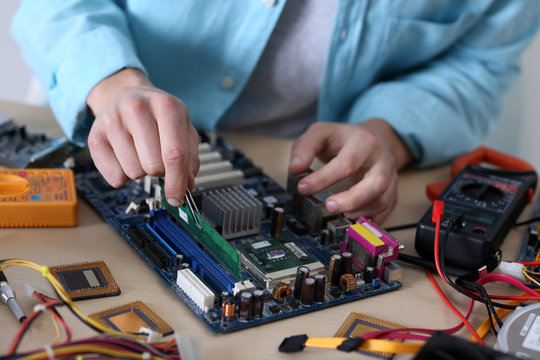 Young Man Repairing Computer Hardware In Service Center