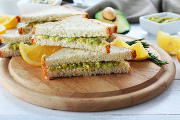 Avocado sandwiches with lemon on cutting board