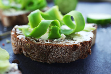 Avocado sandwiches with spices on dark background