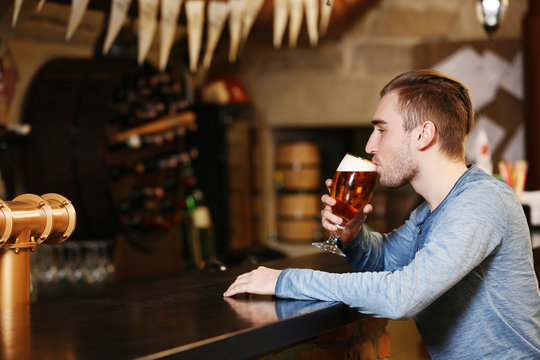 Young man drinking beer in a bar