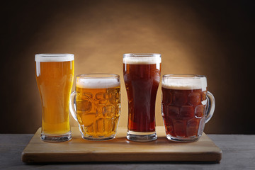 Different sorts of draft beer in glasses on wooden table
