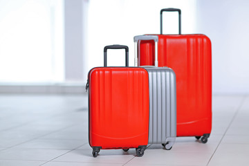 Three polycarbonate suitcases on the floor