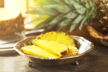 Juicy pineapple slices in silver plate on wooden table