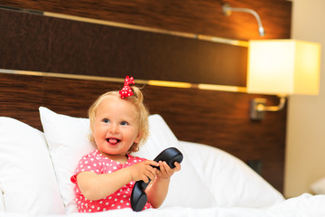 Fototapeta premium cute little girl taking on the phone in hotel room