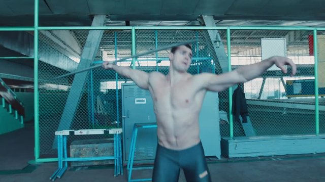 javelin thrower training inside stadium, throwing spear on the rubber training board