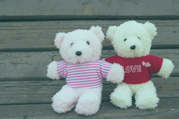 Couple teddy  bears sitting on wooden chair  , love concept in v