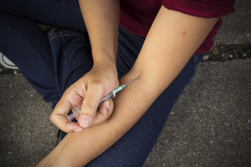 Image of a woman using a syringe. Concepts of drug addiction. Ad