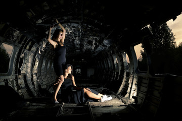 Fototapeta na wymiar girls in ruined airplane
