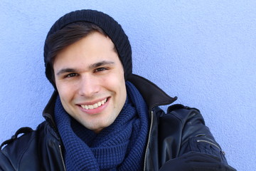 Portrait of man wearing a knitted hat, leather jacket and scarf for the cold weather 