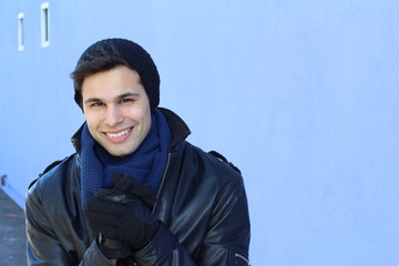 Handsome man in mittens freezes outdoors in winter cold day