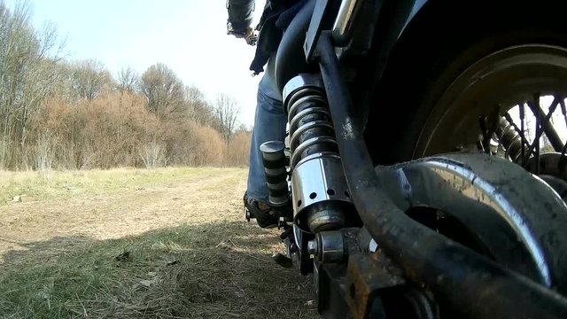Stopping Motorcycle on  dirt rural road, POV view from rear side. Sound


