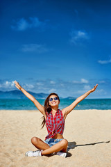 Obraz na płótnie Canvas Young woman with hands raised on the beach