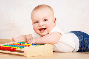 Laughing little toddler playing with abacus