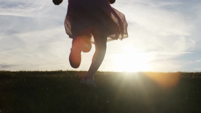Silhouette children running towards the sunset, in slow motion