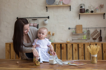 mother with her baby daughter in kitchen together cooking, lifes