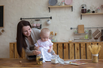 mother with her baby daughter in kitchen together cooking, lifes