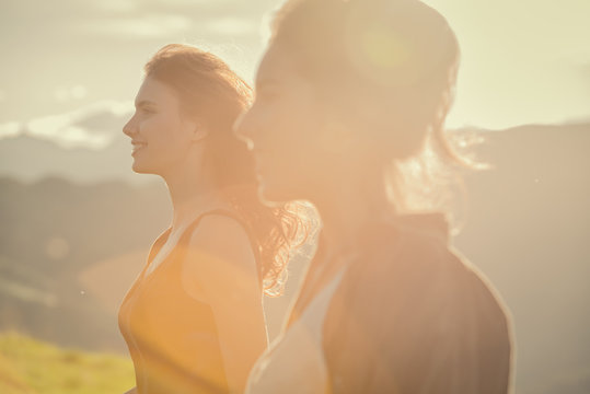 Young Couple Of Woman Looking At Panorama On Mountain During Sunset