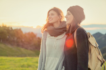 Young women looking at camera hug themselves in nature outdoor
